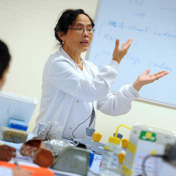 female lecturer in a white coat teaching in a laboratory at 廨̳