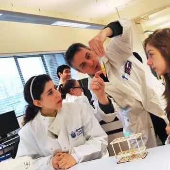 male lecturer explaining an experiment to two students in a science laboratory at 廨̳